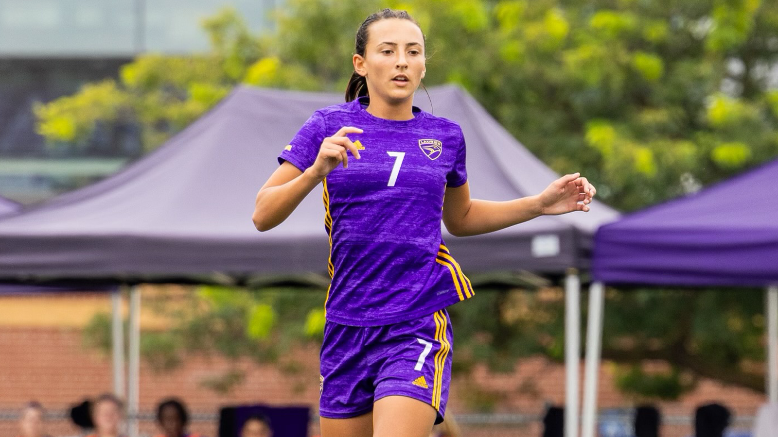 Action photo of Laurier women's soccer player Lexi Kroeker running on the field