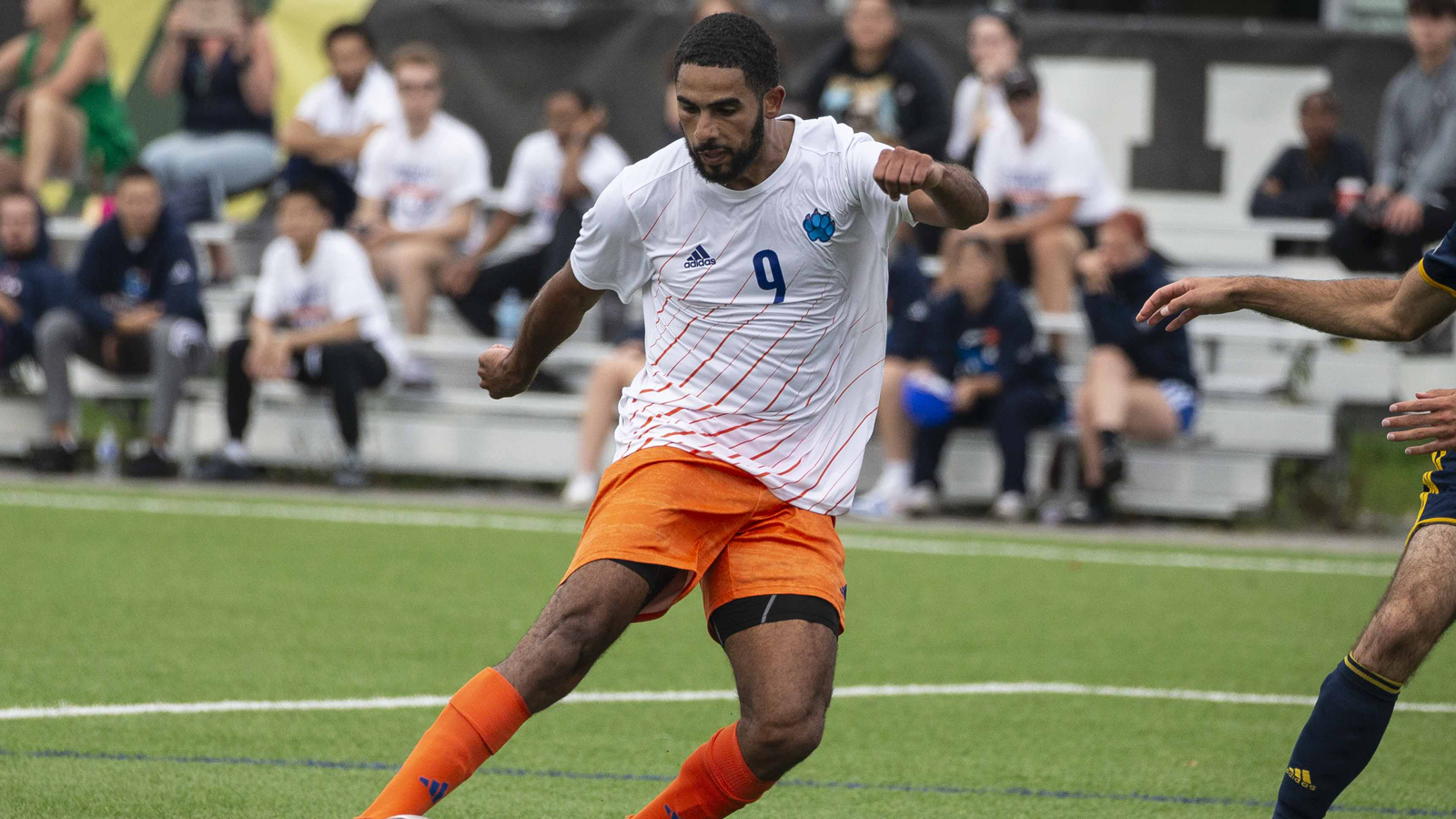 Action photo of Ontario Tech men's soccer player Omar Marzouk kicking the ball during a game