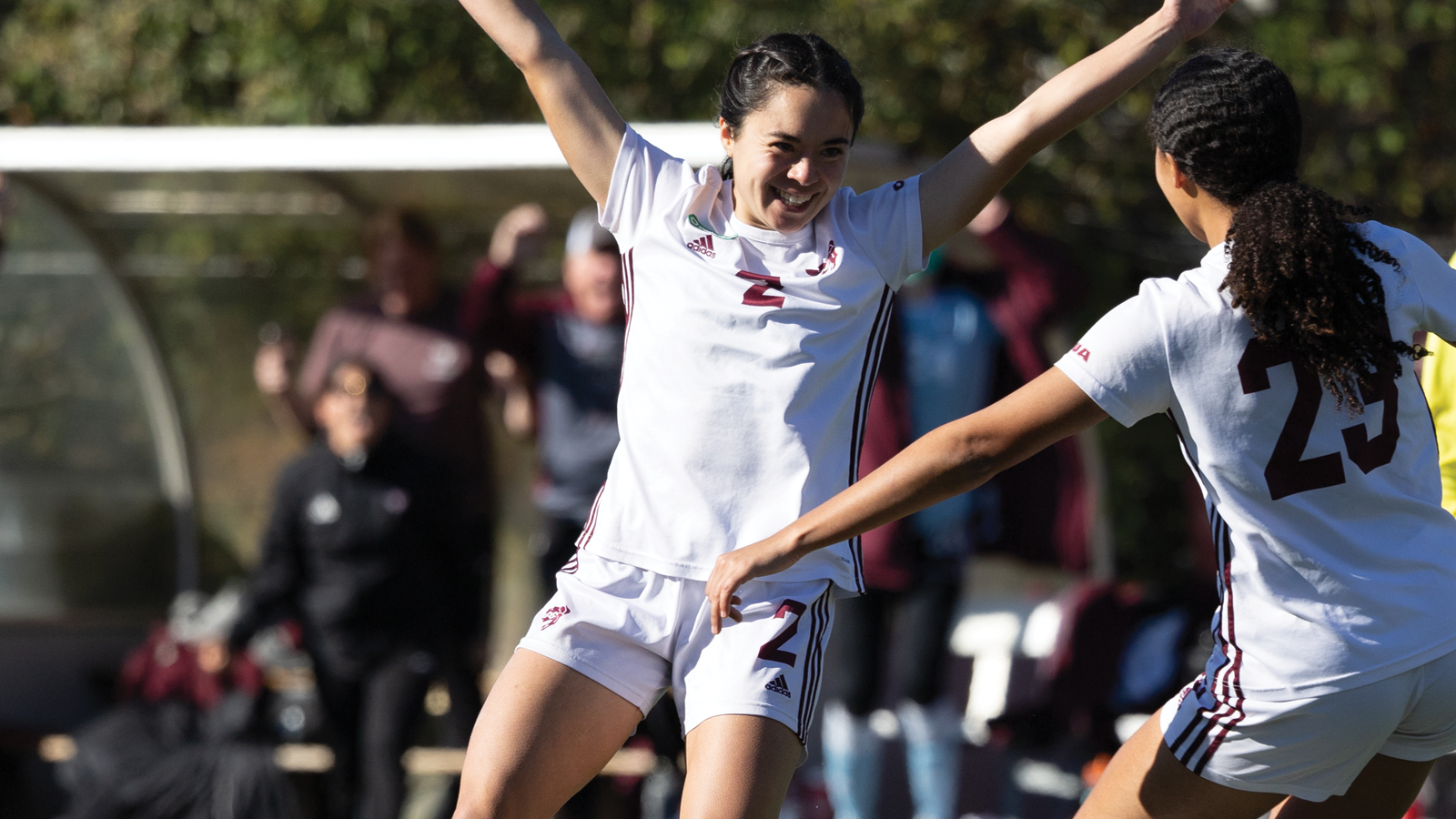 Ottawa women's soccer player Jenna Matsukubo celebrating on the field with her arms raised in the air