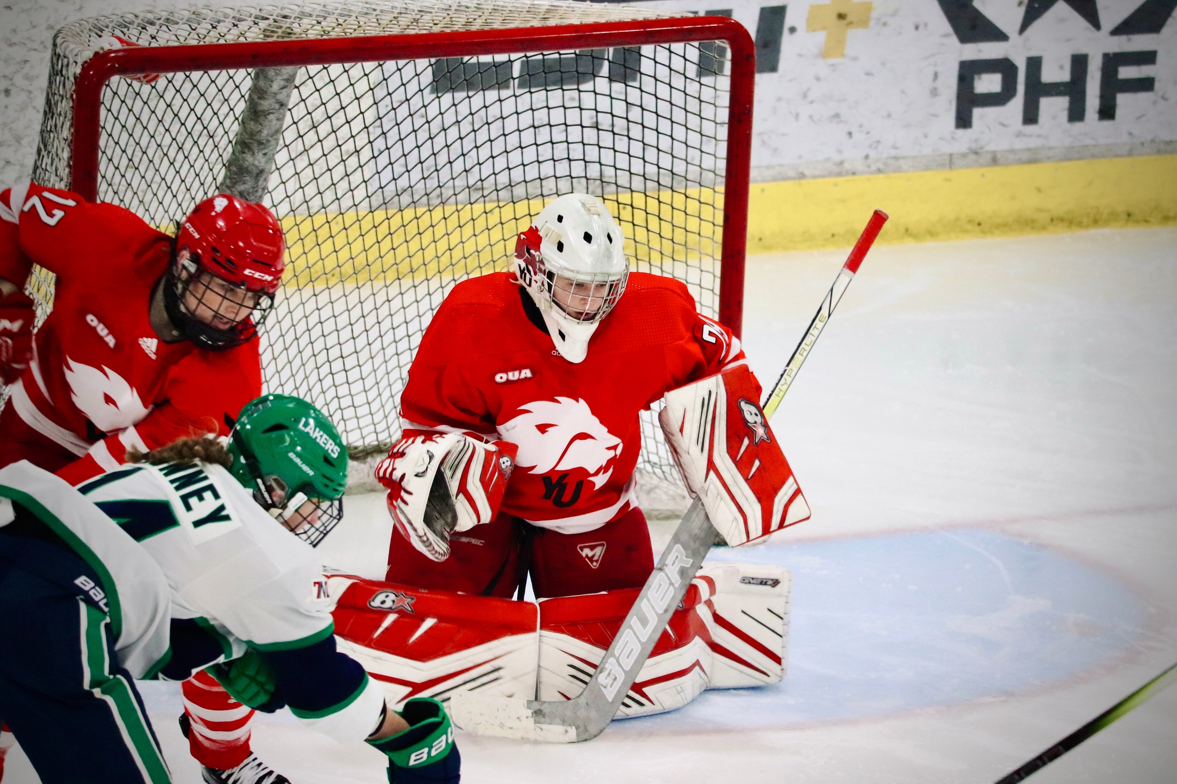 Image of York Women's Hockey Goalie and Athlete of the Week Emma Wedgewood at the net defending against a shot. 