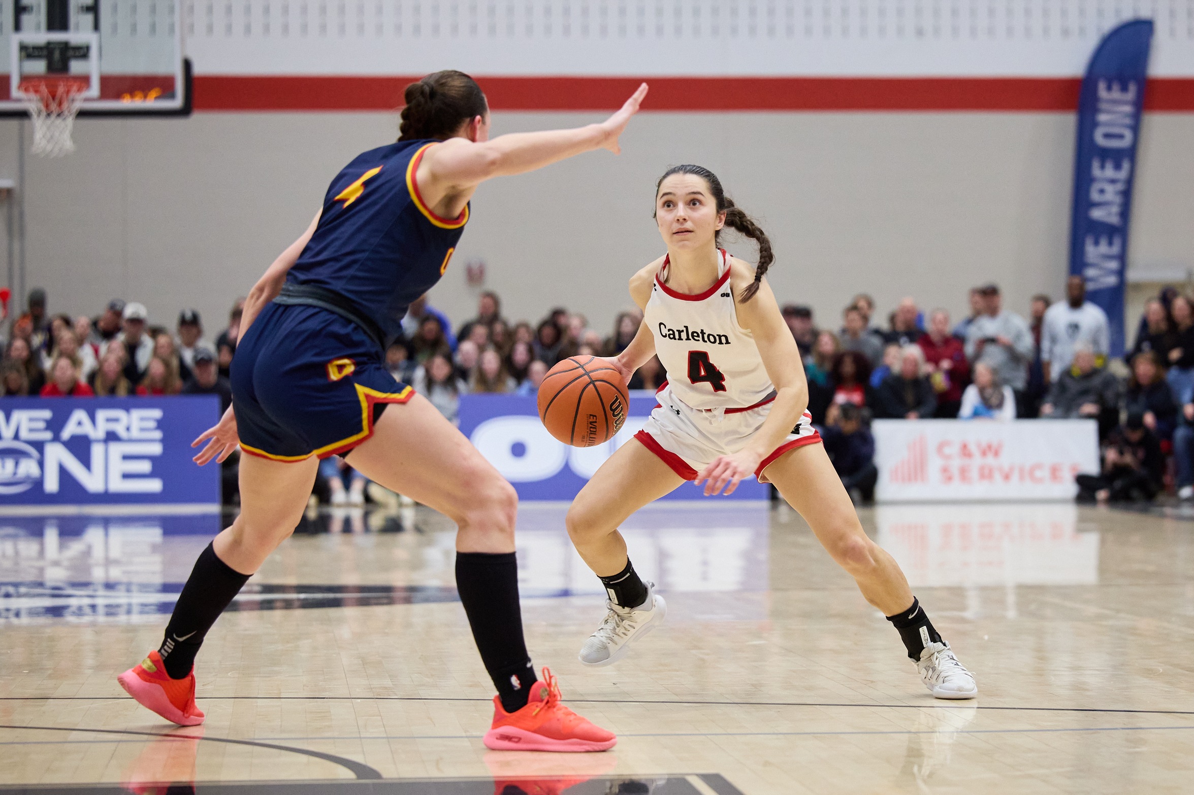 Image of Carleton Basketball Women's basketball player Kali Porcnic dribbling on the court. 