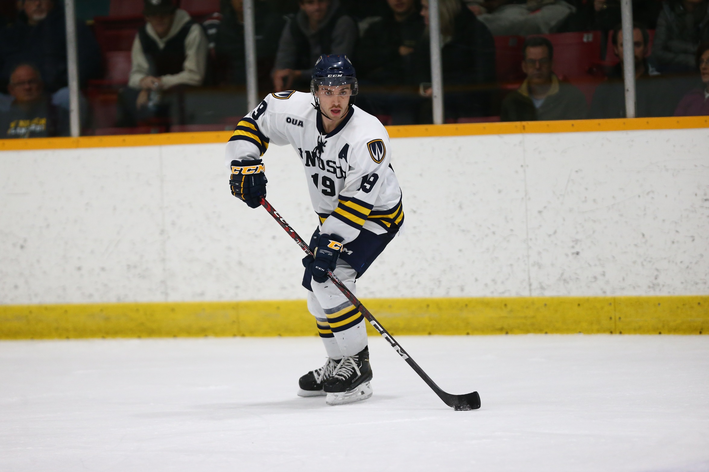 Image of Windsor Men's Hockey Player and Athlete of the Week Holden Wale skating on the ice with this stick in front of him. 