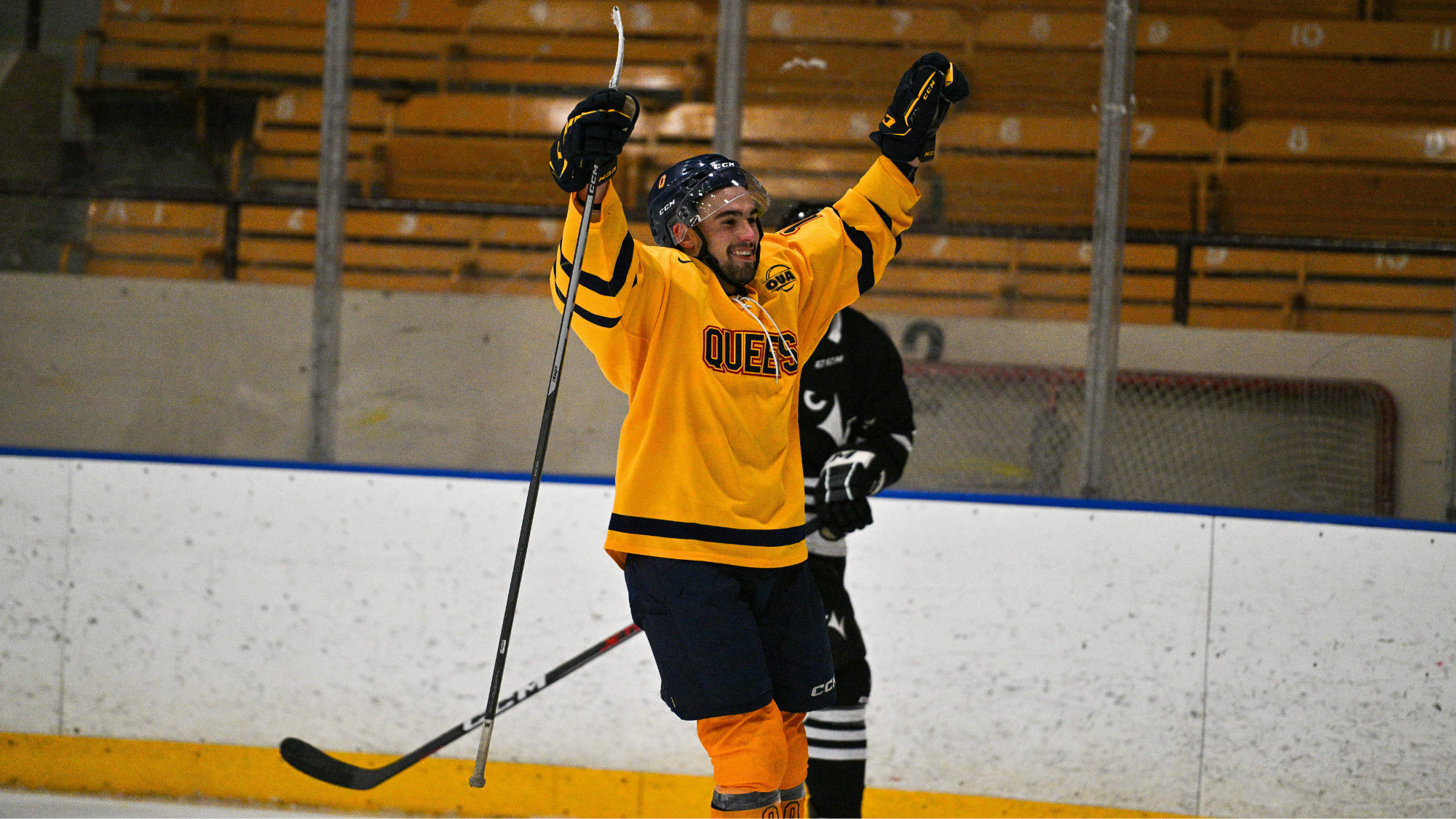 Man in yellow hockey uniform celebrating with his hands in the air