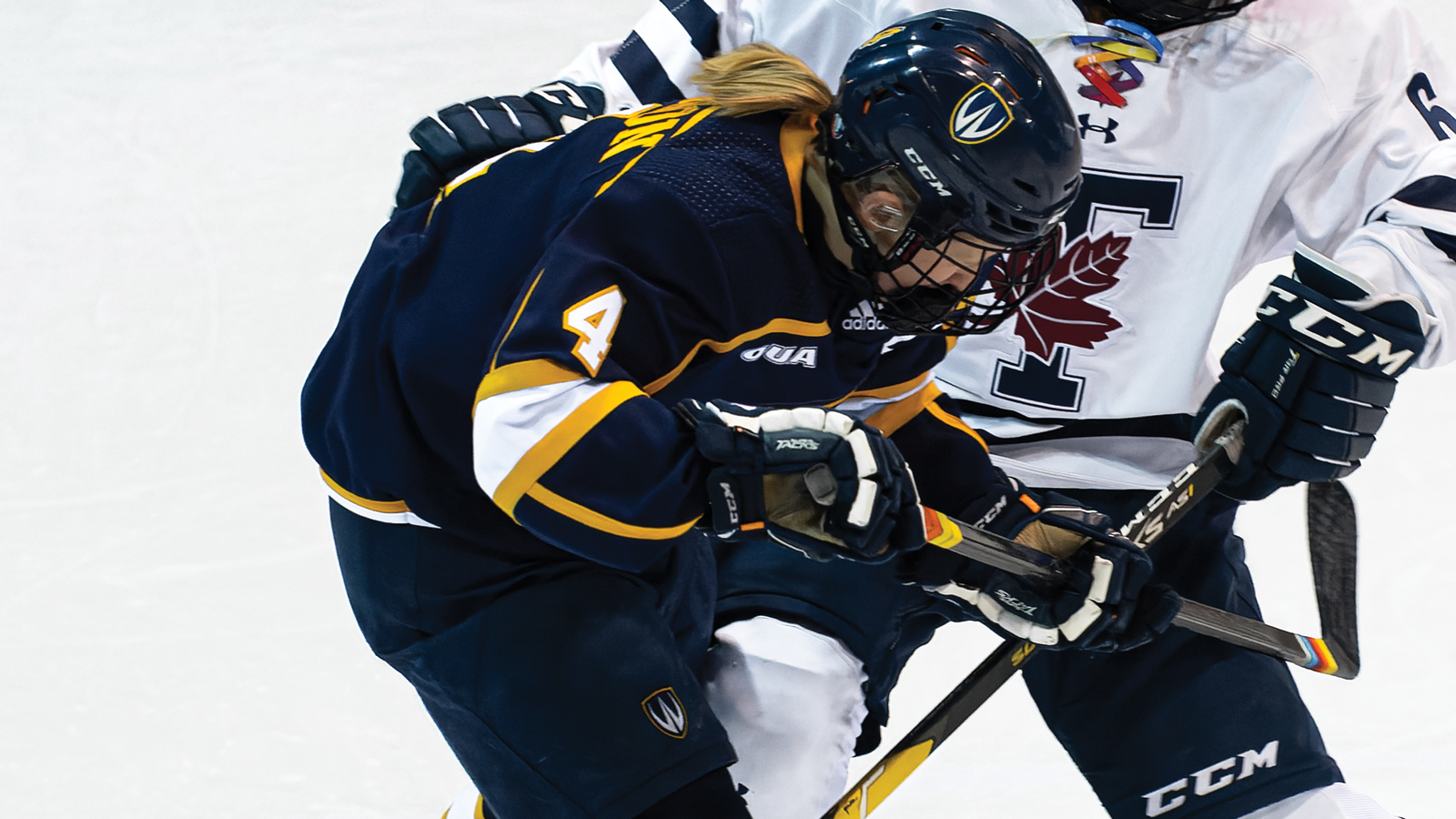 Windsor women's hockey player Jessica Gribbon battling for the puck against an opponent on the ice