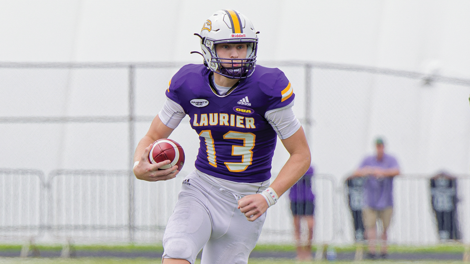 Action photo of Laurier quarterback Taylor Elgersma running with the ball