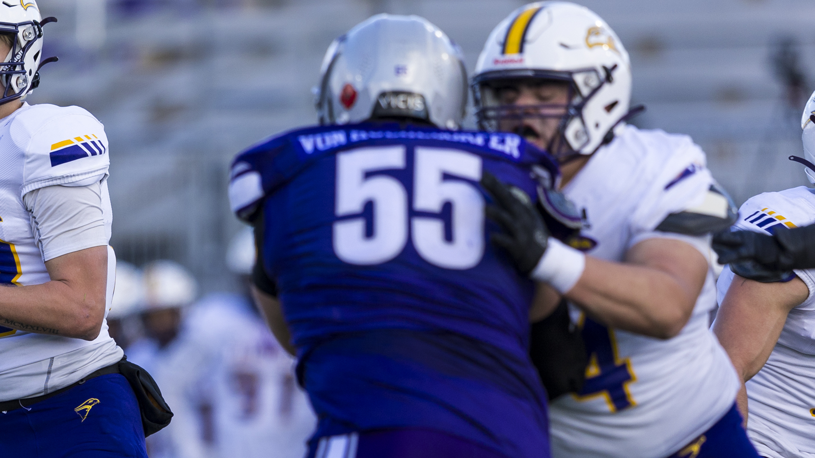 Western football player Max Von Muehldorfer trying to get to the quarterback while being blocked by an opposing player