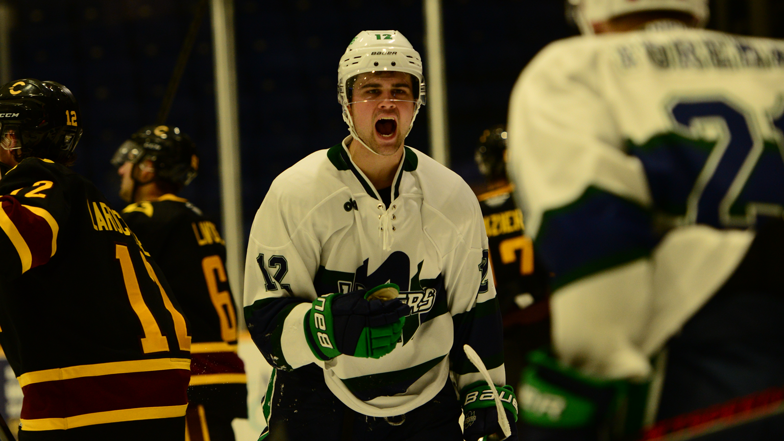 Nipissing men's hockey player shouting in celebration on the ice after scoring a goal