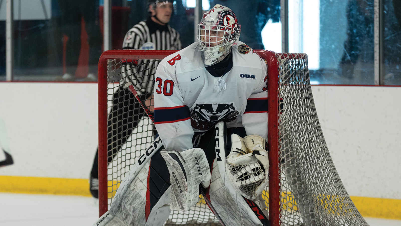 Brock hockey goalie Connor Ungar standing in his net while pressed up against the post as he looks out toward the play during a game