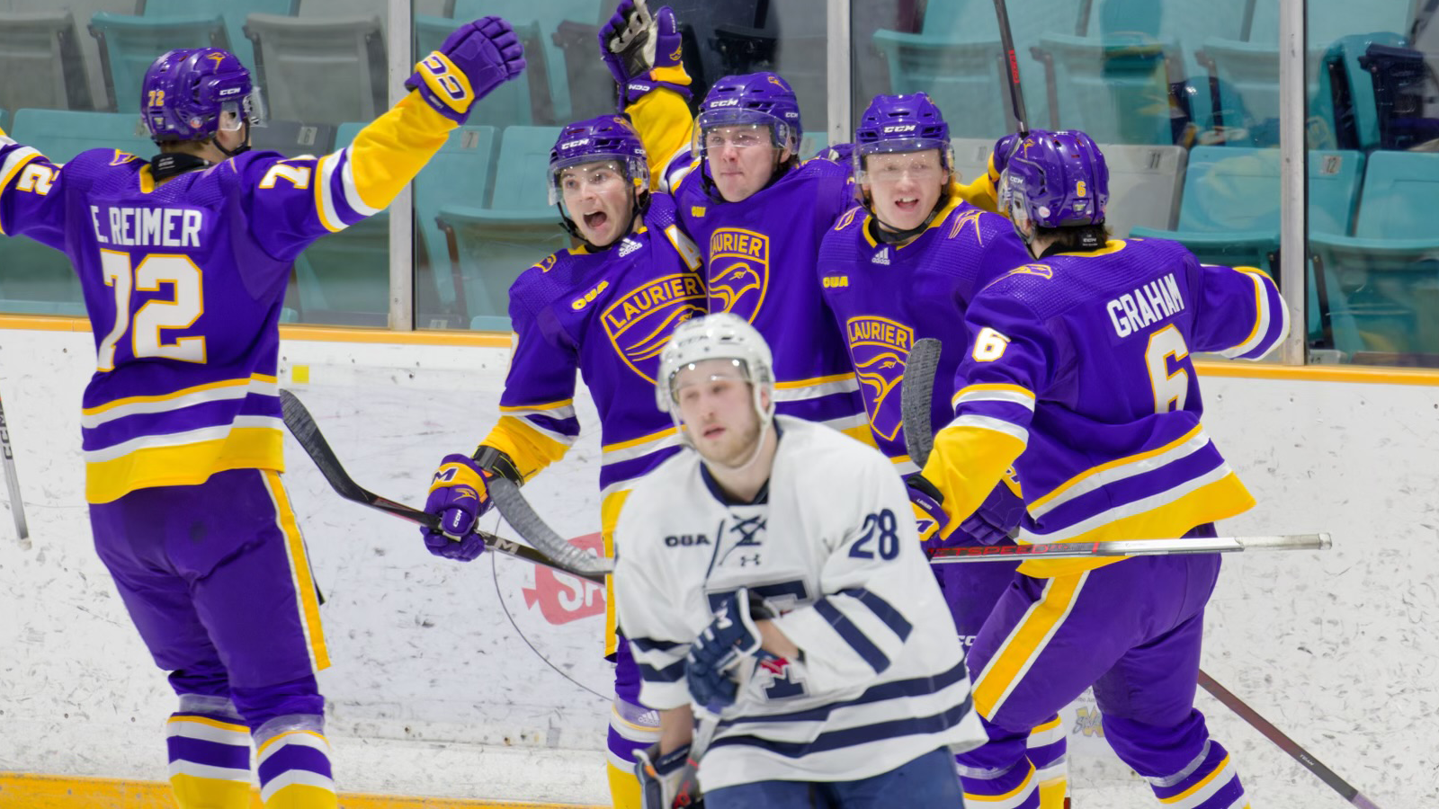 Five members of the Laurier men's hockey team celebrating a goal on the ice