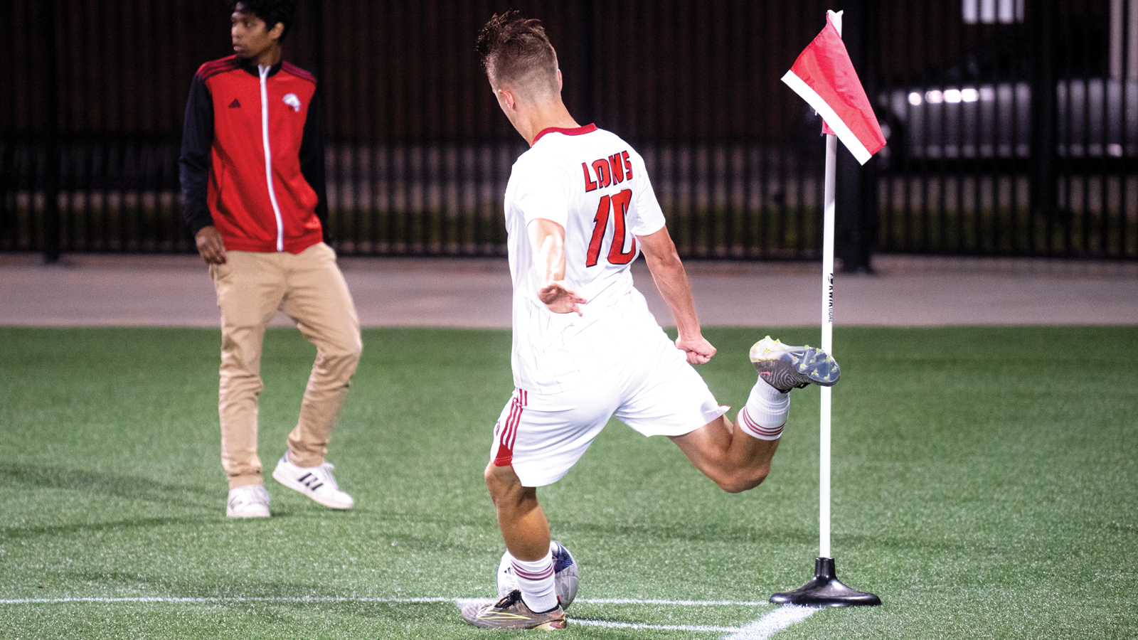 York men's soccer player Christian Zeppieri in the midst of taking a corner kick during a game