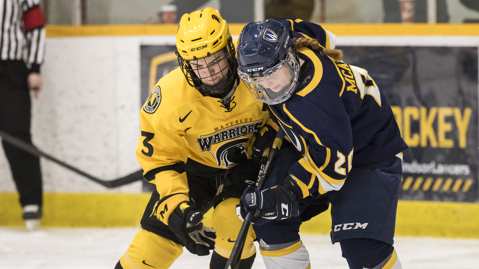 Women's hockey players from Waterloo Warriors and Windsor Lancers battling for the puck on the ice during a game