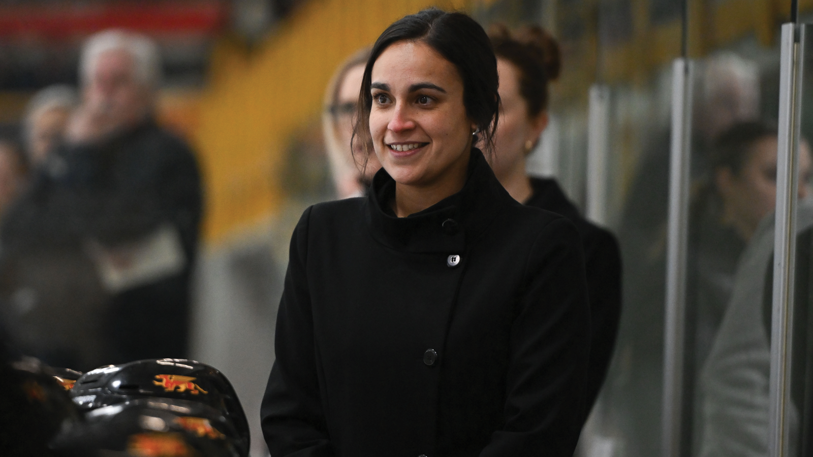 Guelph women's hockey coach Katie Mora standing behind the bench during a game