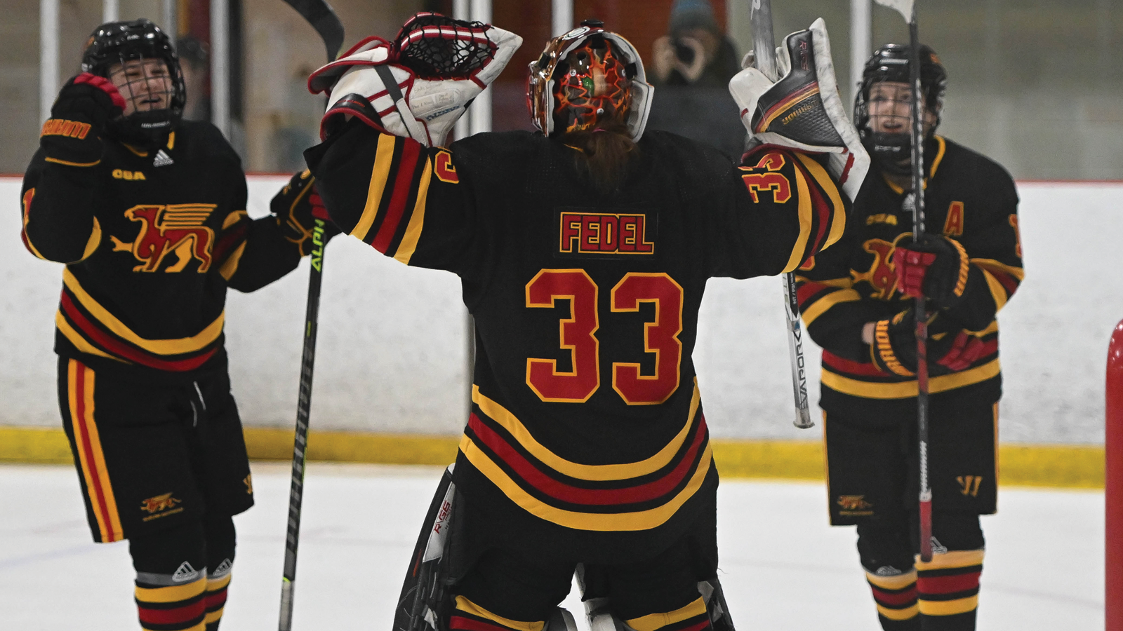Guelph women's hockey goalie Martina Fedel celebrating on the ice with two of her teammates after a win