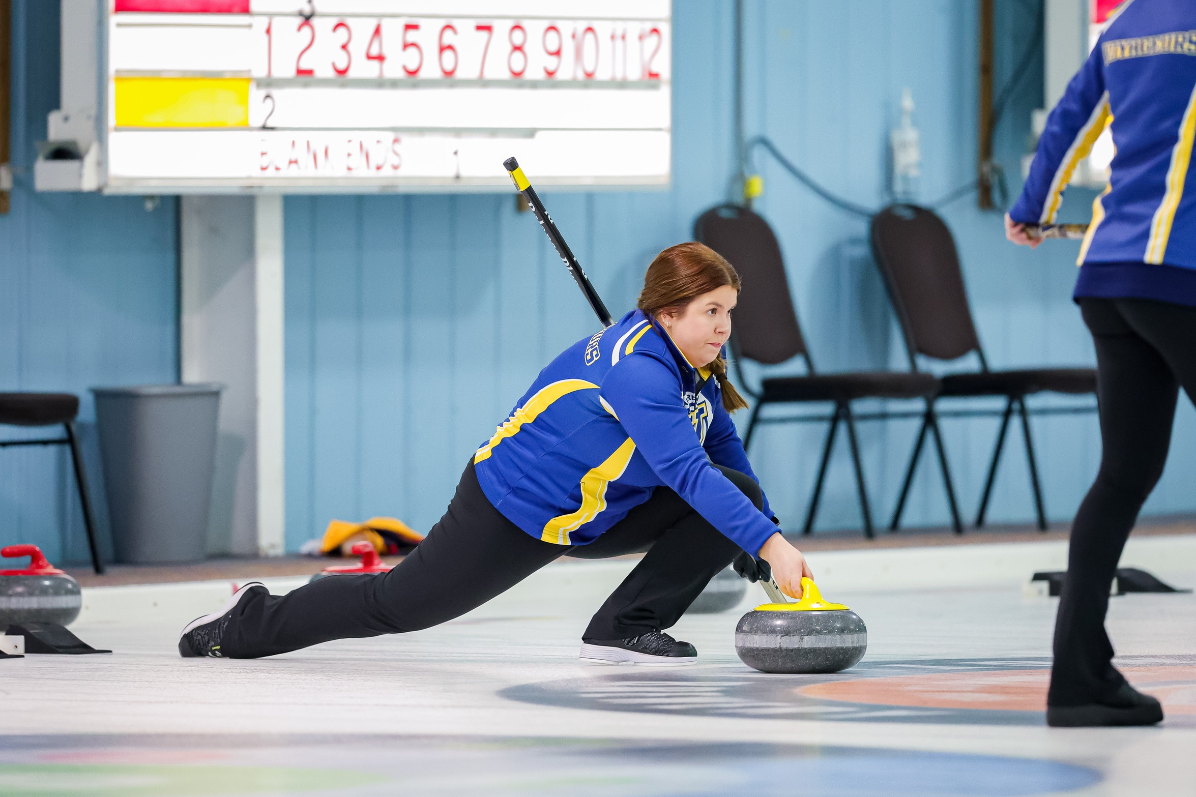 image of curling skip Bella Lehtimaki Croisier lunging forward on the ice