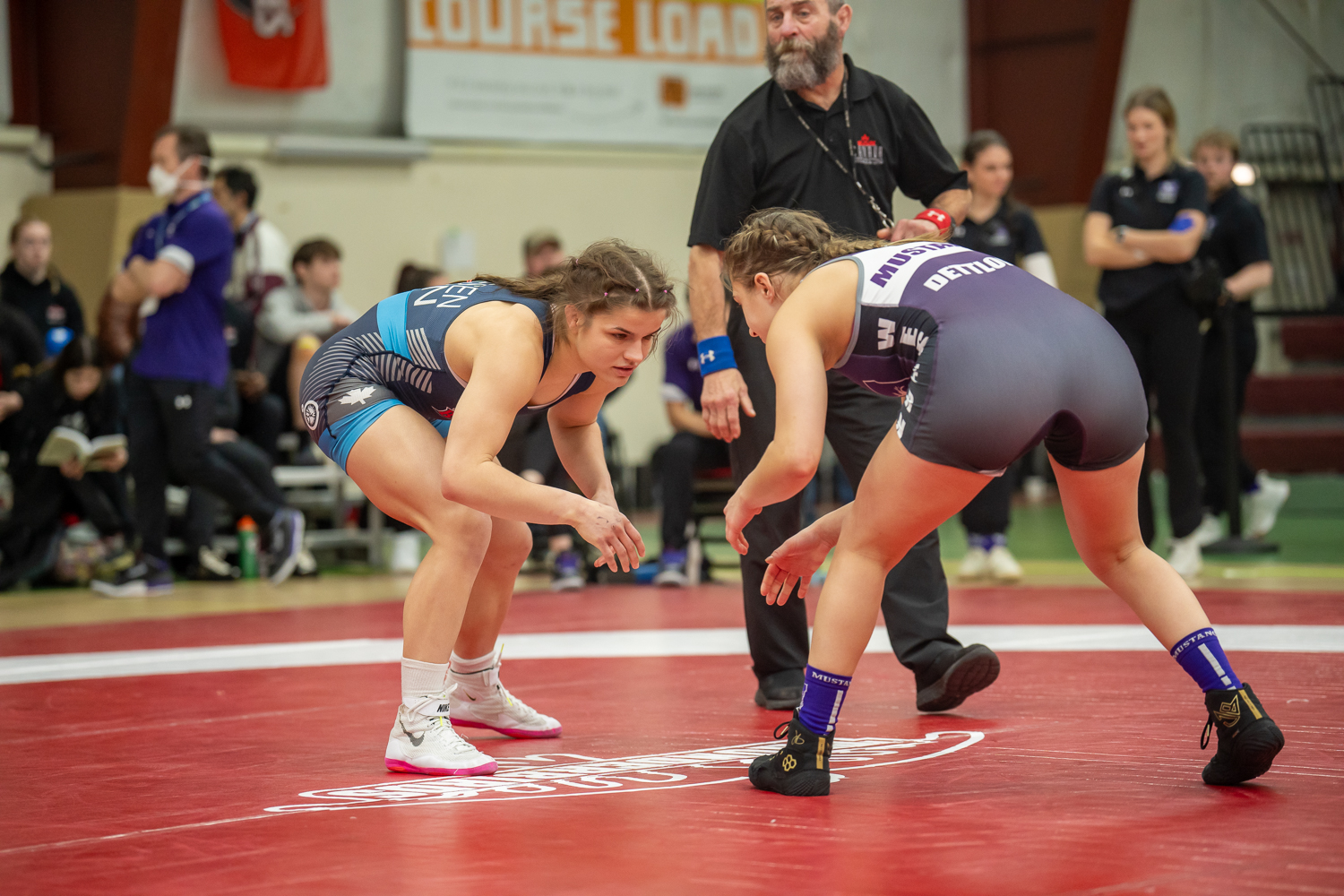 Image of Brock Women's Wrestling player Mia Friesen on the mat in a ready position